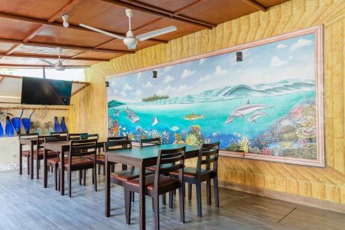 a dining room with a large painting on the wall at MEHEL - Holiday Home - Mahibadhoo in Mahibadhoo