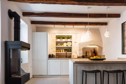 a kitchen with a stove and a counter with chairs at Villa Lemonia in Rethymno Town