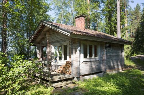 a small log cabin in the middle of a forest at Tervalepikon Torpat in Sysmä