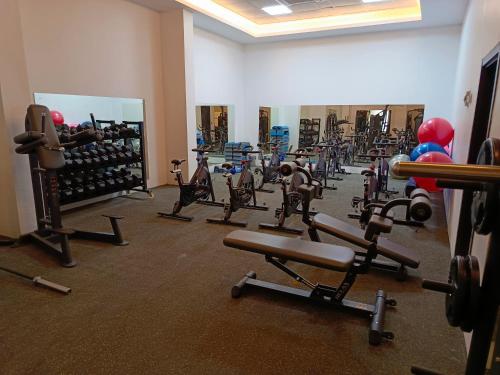 a gym with rows of exercise equipment in a room at Hill Top Muscat in Muscat