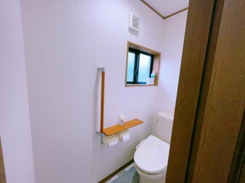 a bathroom with a toilet with a mirror and a window at Miyama House in Hachioji