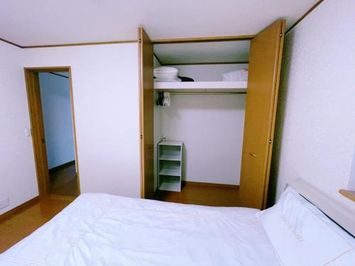 a bedroom with a bed and a closet at Miyama House in Hachioji