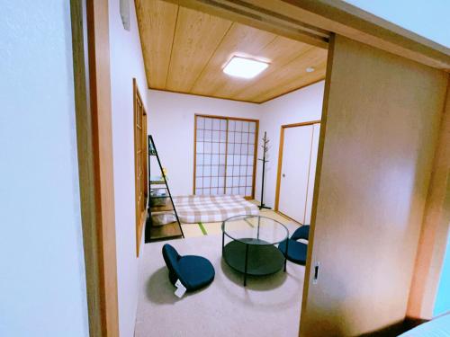 a room with a glass table and some chairs at Miyama House in Hachioji