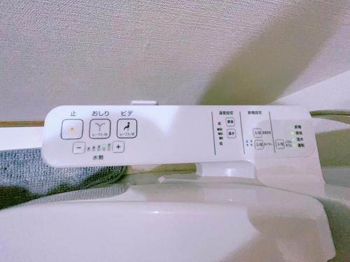 a remote control sitting on top of a toilet at Miyama House in Hachioji