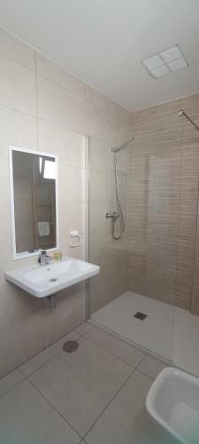 y baño blanco con lavabo y ducha. en APARTAMENTO TURISTICO EN LEBRIJA, en Lebrija