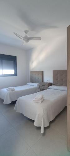 1 dormitorio con 2 camas y ventilador de techo en APARTAMENTO TURISTICO EN LEBRIJA, en Lebrija