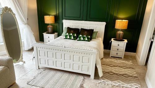 a bedroom with a white bed with green walls at Beaufort House Accomodation in New Ross