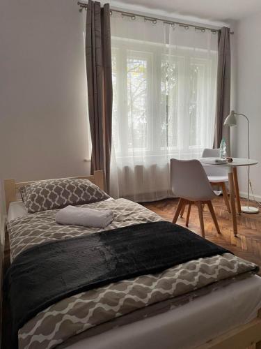 een slaapkamer met een bed, een tafel en een raam bij Simply Great in Toruń