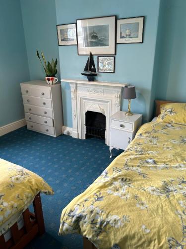 a bedroom with two beds and a fireplace at Grace Stays in Ellesmere Port