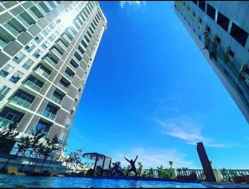 a person standing in the water in front of a building at Unit 3J Signature Suites, Lafayette Megaworld in Iloilo City