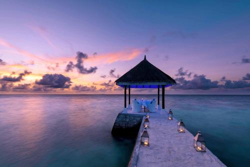 a pier with chairs and a gazebo in the water at OBLU NATURE Helengeli-All-Inclusive with free Transfers in North Male Atoll