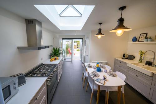 a kitchen with a table and a stove top oven at Pilots Lodge by Deal Castle with free parking in Deal
