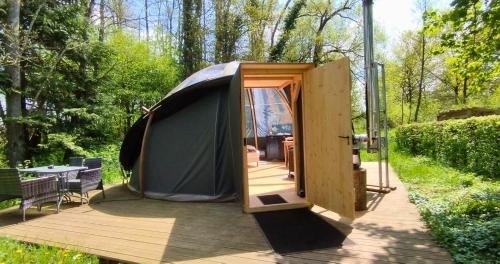 namiot z otwartymi drzwiami na drewnianym tarasie w obiekcie Bulle forestière - Etat Nature w mieście Magnières