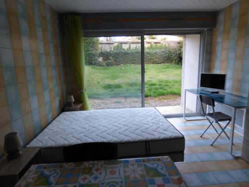 1 dormitorio con 1 cama y escritorio con ordenador en Le Parc, en Brioude