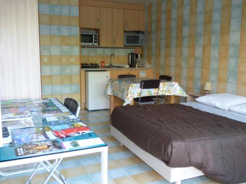 a bedroom with a bed and a table and a kitchen at Le Parc in Brioude
