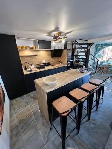 a kitchen with a counter and some stools in it at Villa moderne 3 chambres double , proche de la mer, le Micocoulier quartier sainte Marguerite in La Garde