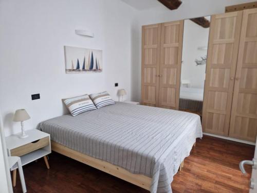 a bedroom with a bed and two wooden doors at Appartamento Profumo di Mare in Camogli