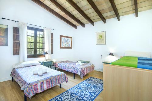 Zimmer mit 2 Betten und 2 Tischen in der Unterkunft Owl Booking Villa Can Francisco - Family and Friends in El Port