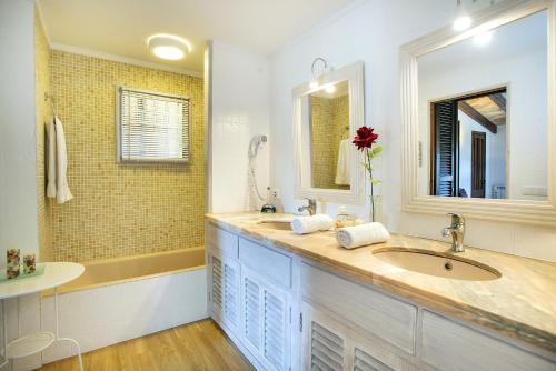 ein Badezimmer mit einem Waschbecken und einem großen Spiegel in der Unterkunft Owl Booking Villa Can Francisco - Family and Friends in El Port
