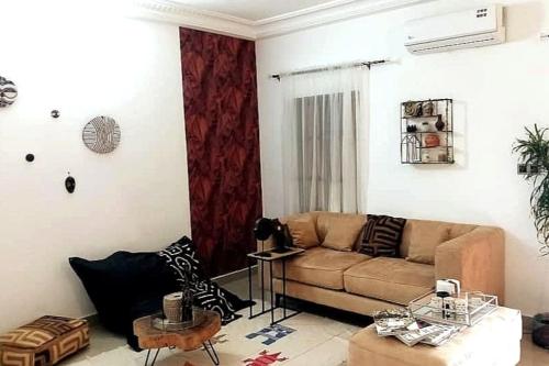 uma sala de estar com um sofá e uma mesa em 3 pièces moderne africain à 2min de la plage, à Fidjrosse em Cotonou
