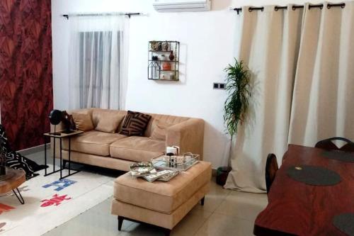 uma sala de estar com um sofá e uma mesa em 3 pièces moderne africain à 2min de la plage, à Fidjrosse em Cotonou