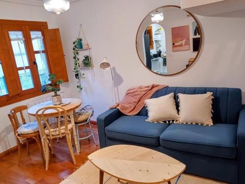 sala de estar con sofá azul y mesa en Casa El Tesorillo en Toledo