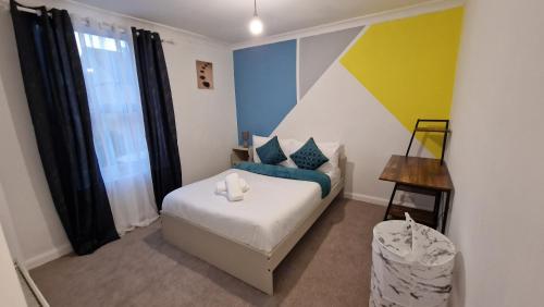 een kleine slaapkamer met een bed en een raam bij Beautiful 2-Bed House in Gillingham in Gillingham