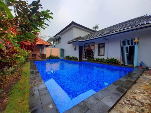 eine Villa mit einem Pool vor einem Haus in der Unterkunft Villa batu malang swimming pool in Batu