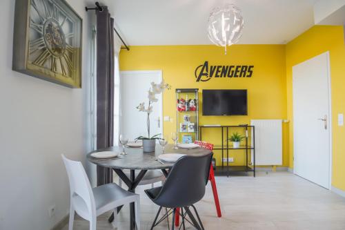 a dining room with a table and chairs and a yellow wall at Air-conditioned apartment, walking distance to disney - DISNEY MAGICAL HOMES, PARIS in Serris