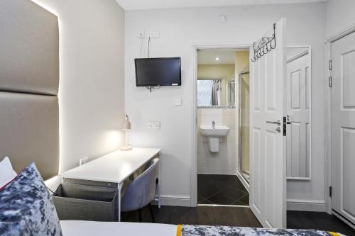 a room with a bed and a bathroom with a sink at Single Studio Flat in London