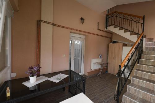 Vrnjačka BanjaにあるCapitol Apartmaniのリビングルーム(階段、テーブル付)
