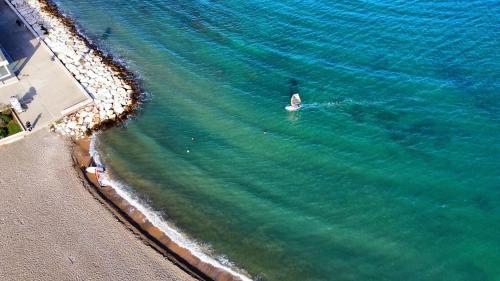 an aerial view of a person swimming in the ocean at Oltremare Luxury Suites in Bari