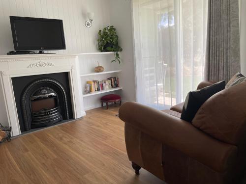 a living room with a couch and a fireplace at Vineyard Views Rutherglen in Rutherglen