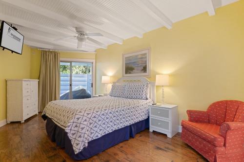 a bedroom with a bed and a chair and a window at East Beach Villa Unit 204 in East End