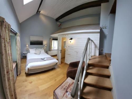 um quarto com uma cama e escadas num quarto em B&B Le Valangré em Chaumont-Gistoux