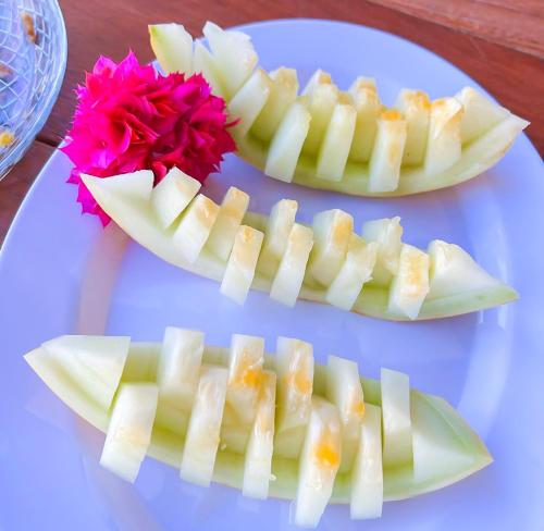 two slices of apple on a plate with a flower at Chalés Milagres Beach in São Miguel dos Milagres