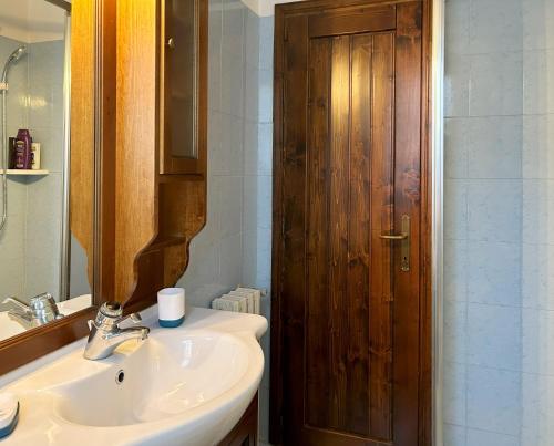 La salle de bains est pourvue d'un lavabo et d'une porte en bois. dans l'établissement Cremeno Hidden Garden, à Cremeno