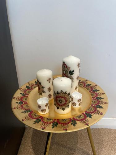 Una mesa con cuatro velas y tazas. en NISHAT & AMAAN en Broadwater