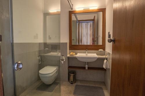 bagno con servizi igienici, lavandino e specchio di Hotel Onrock a Ella