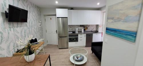 a kitchen with a refrigerator and a table in a room at Estudio independiente Forget Me Not in Getxo