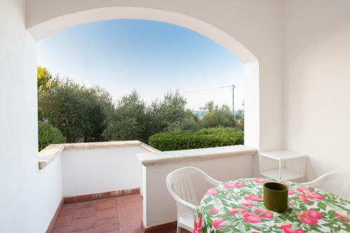einen Balkon mit einem Tisch und Stühlen sowie einem Fenster in der Unterkunft Centro Vacanze Piccolo Friuli in Vieste