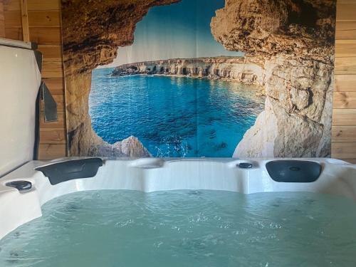 a bath tub with a painting of a cave at loch lomond apartments in Alexandria