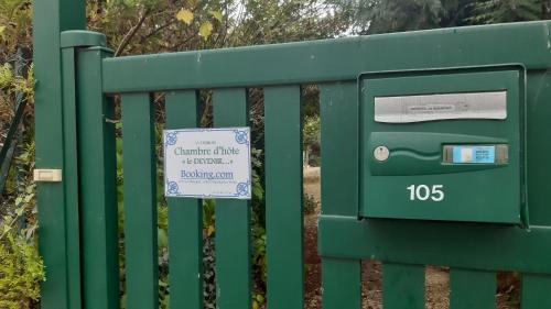 Una cerca verde con una caja de correo. en 1 Chambre double "Le Devenir" en Saint-Julien-les-Villas