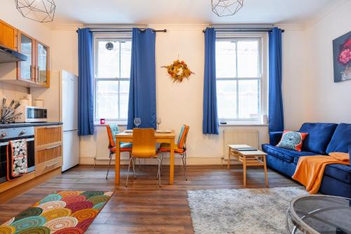 a living room with a blue couch and a table at Lovely One Bed in the Heart of Covent Garden in London