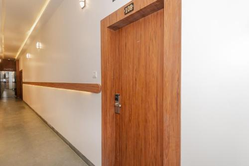 a wooden door in a hallway next to a wall at Hotel Zillion Executive Near US Consulate Bandra Kurla Complex Mumbai Near Mumbai Airport Mumbai in Mumbai