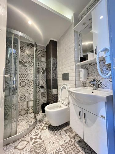 a bathroom with a sink and a shower and a toilet at The Sisli Luxury Corner Suit in Istanbul