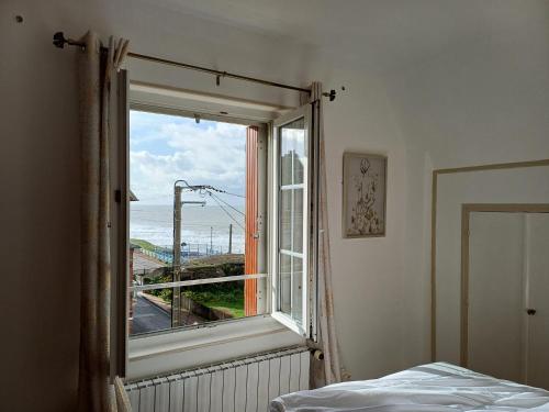 1 dormitorio con ventana y vistas al océano en Au gré des marées 2 appartement face à la mer 2ème étage, en Ault