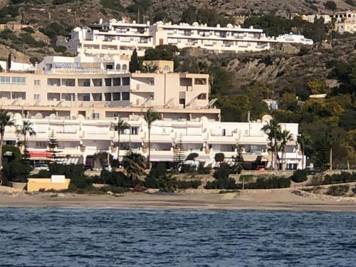 a large white building on the shore of a beach at mirazul mojacar in Mojácar