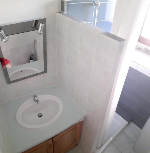 une salle de bain avec un lavabo et un miroir dans l'établissement Gîte le MAGNAN, 55 m2, au calme, terrasse, jardin, piscine chauffée, sud Ardèche, à Joyeuse