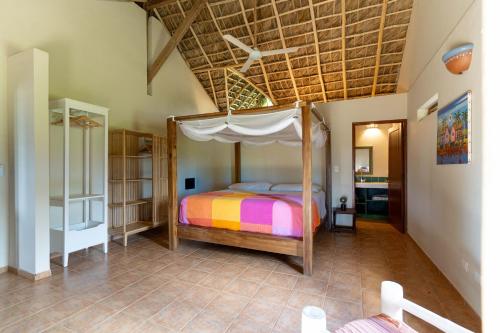 Villa Punta Coral في لاس غاليراس: غرفة نوم بسرير مع مظلة